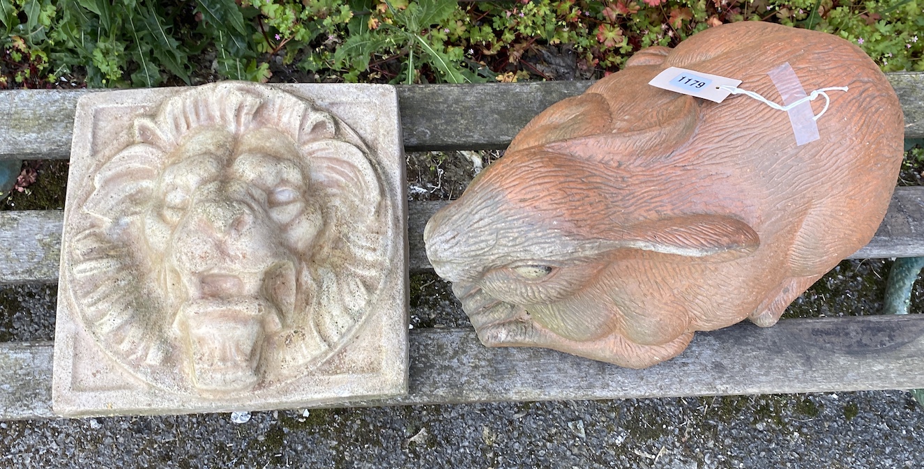 A terracotta rabbit garden ornament length 50cm, and a reconstituted stone lion mask wall appliqué